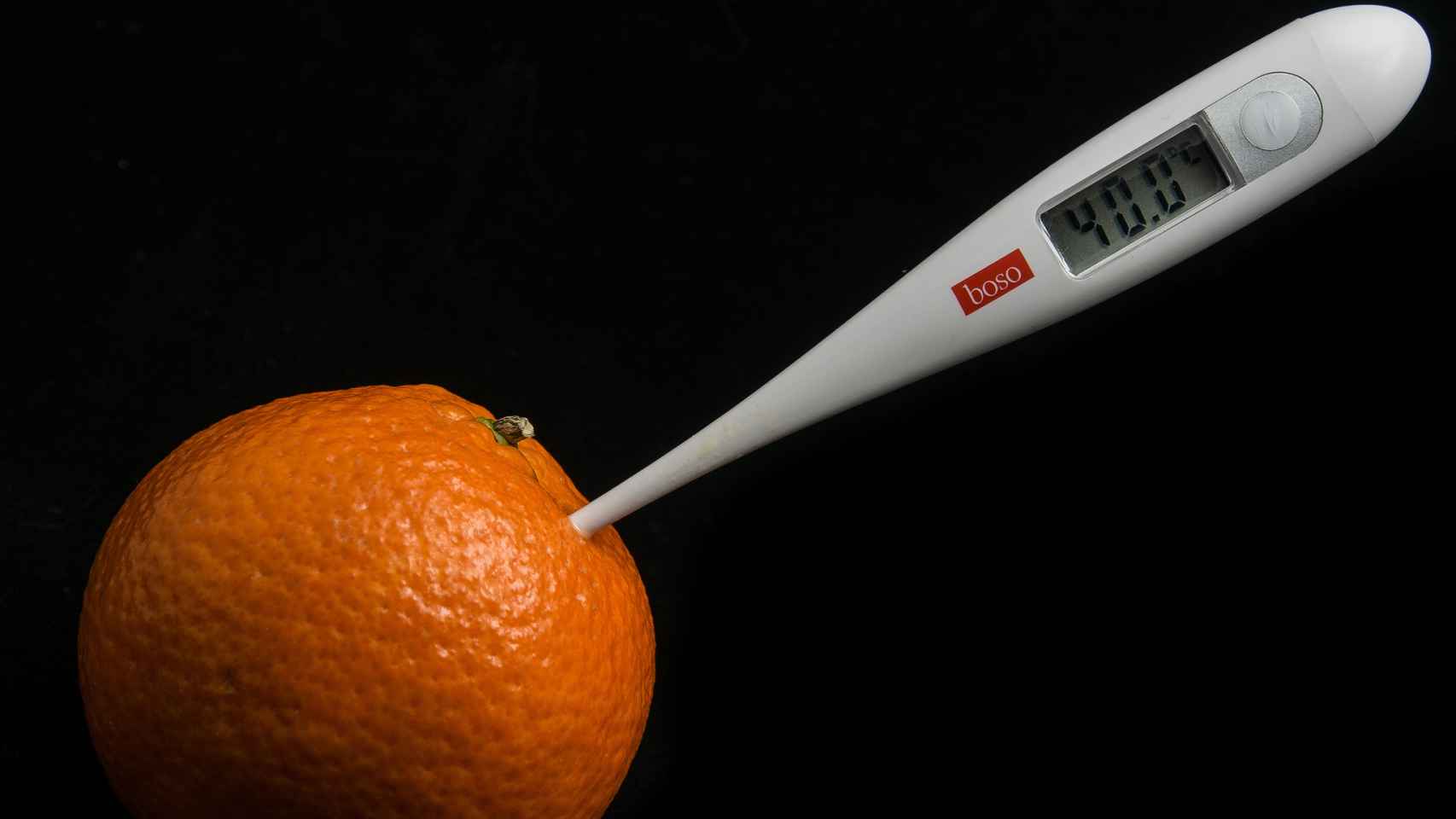 Una mandarina con un termómetro. Menudo bodegón.