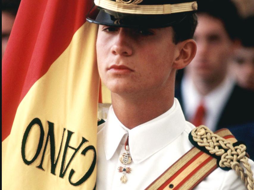 El entonces príncipe con uniforme de cadete y la bandera del buque Juan Sebastián Elcano durante un acto oficial.