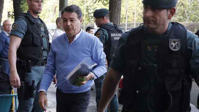 Ignacio González acompañado por varios agentes durante el registro en su oficina