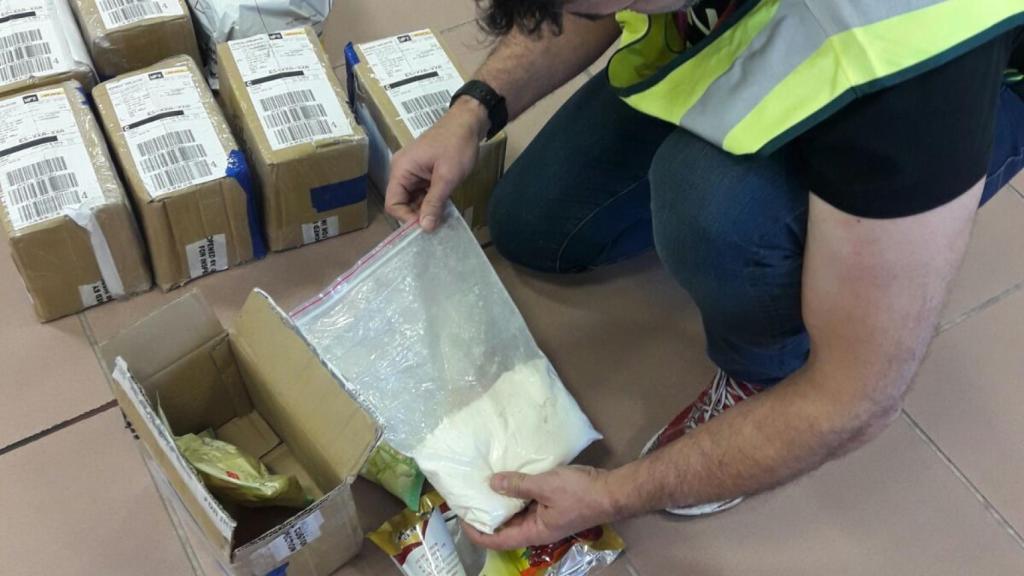 Un agente de la Guardia Civil de Alicante observa el contenido de la bolsa de droga.