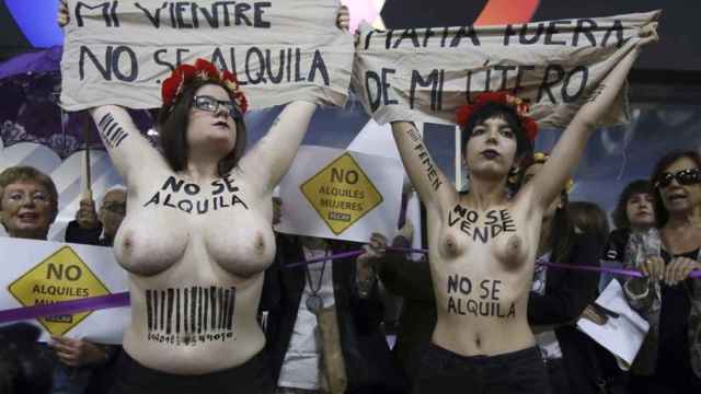 Activistas de Femen despliegan sus pancartas ante la feria de gestación subrogada celebrada en Madrid