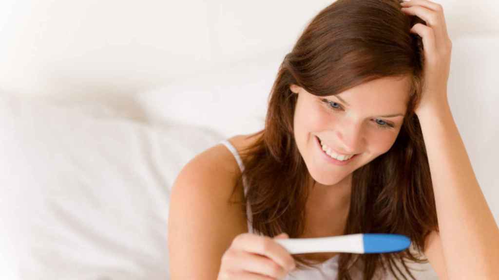 Una mujer lee un test de embarazo