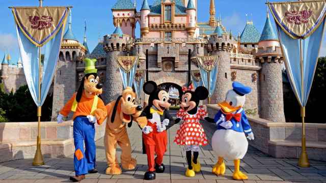 Goofy, Pluto, Mickey, Minnie y el pato Donald frente al castillo de Disney World.
