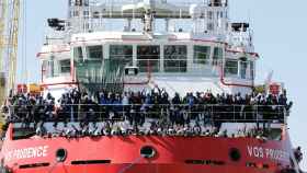 Un grupo de migrantes esperan para desembarcar en el puerto de Nápoles