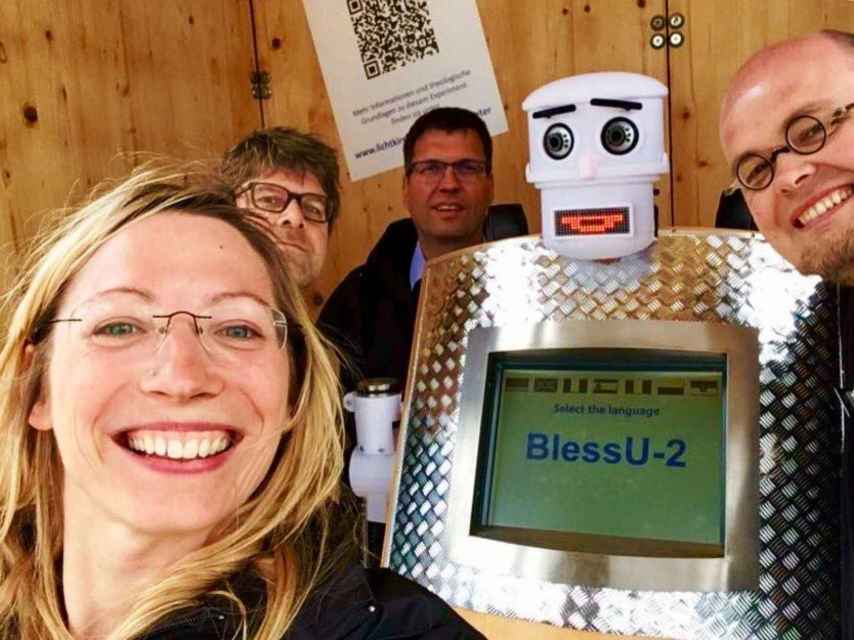 El primer robot que imparte bendiciones, junto a su equipo de creadores alemanes.