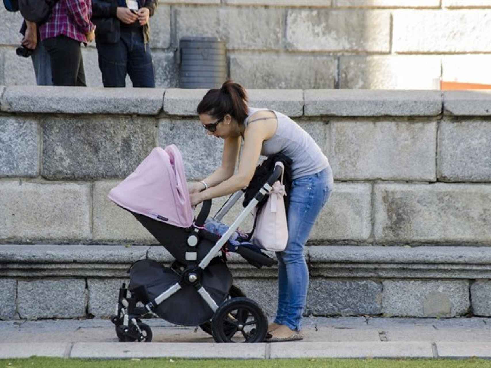 Una madre atiende a su bebé en la calle