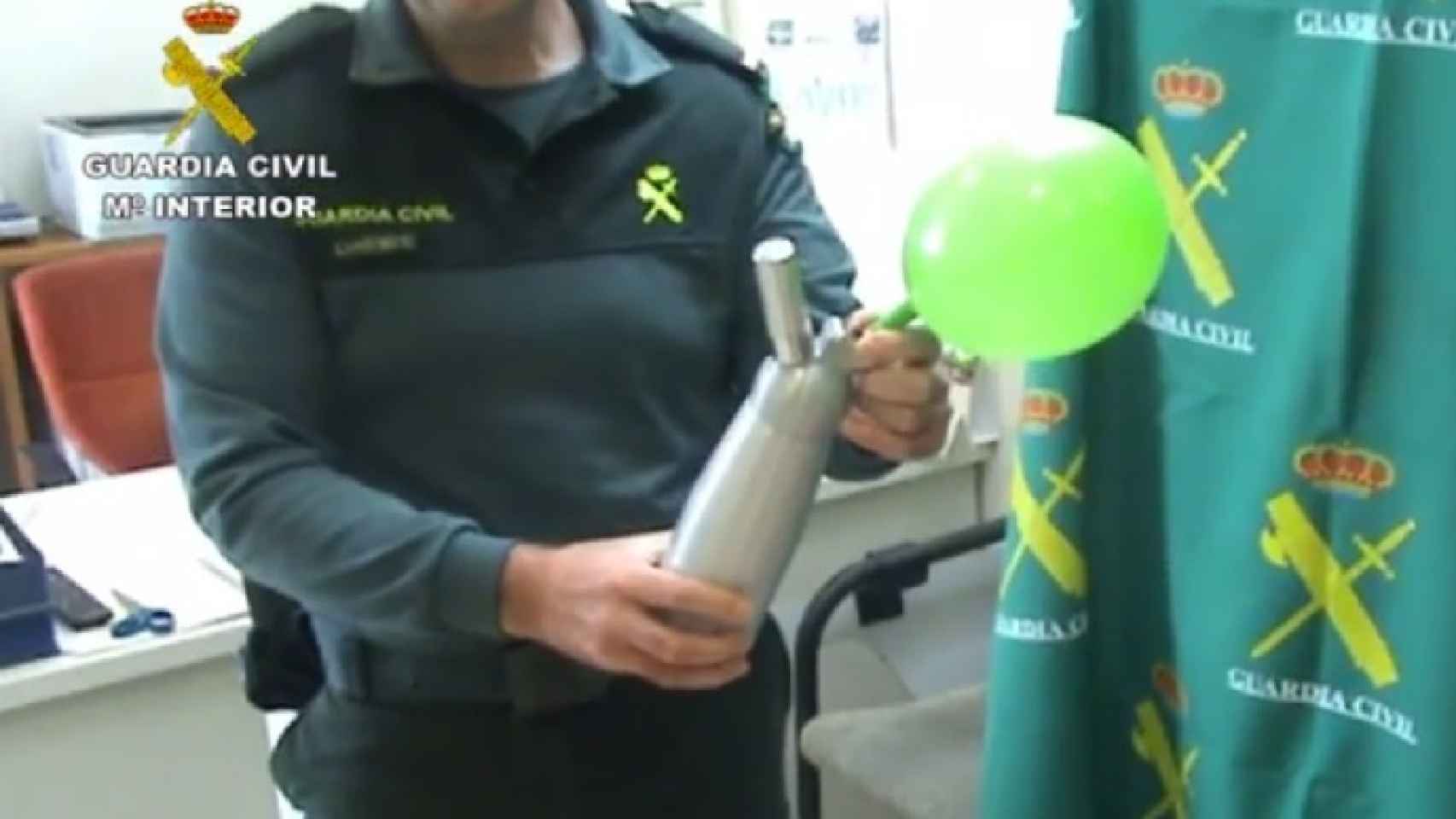 Un agente de la Guardia Civil muestra cómo se infla un globo con óxido nitroso