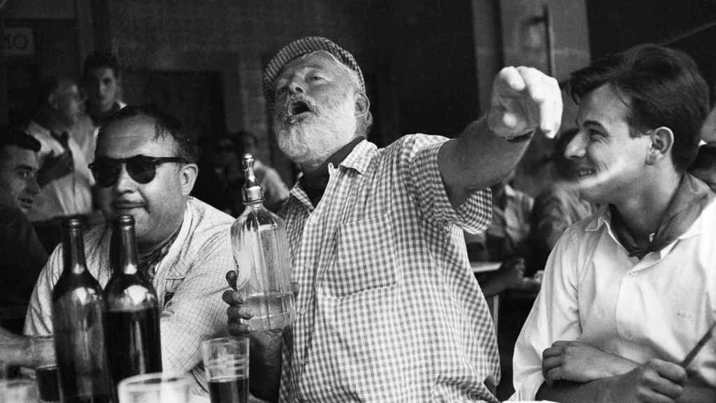 Hemingway bromea en una mesa en la Pamplona de los cincuenta.