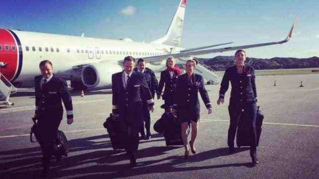 Un grupo de tripulantes de  Norwegian caminan por el aeropuerto.