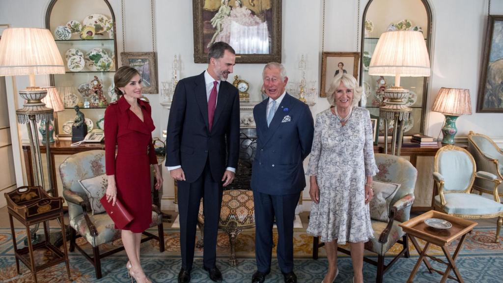 La reina eligió un vestido gabardina en color burdeos para su encuentro con con Carlos de Inglaterra y la duquesa de Cornualles.