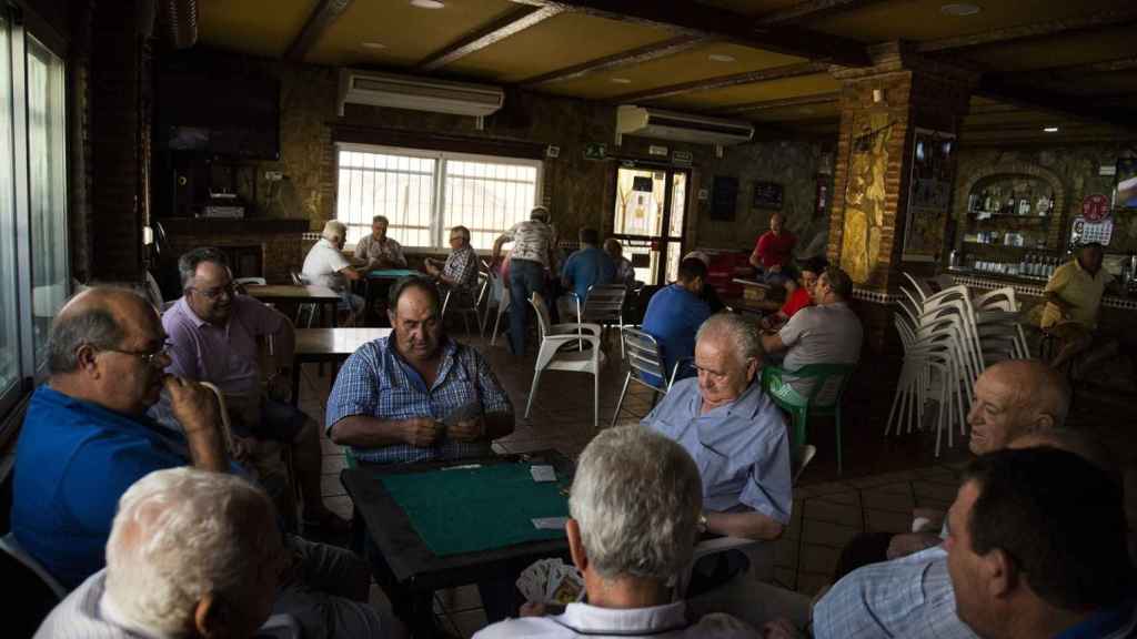 Jornaleros jubilados pasan la tarde jugando al dominó en un bar de Jabalquinto (Jaén)