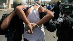 Las fuerzas de seguridad de Israel detienen a uno de los palestinos que han participado en las manifestaciones del 21 de julio.