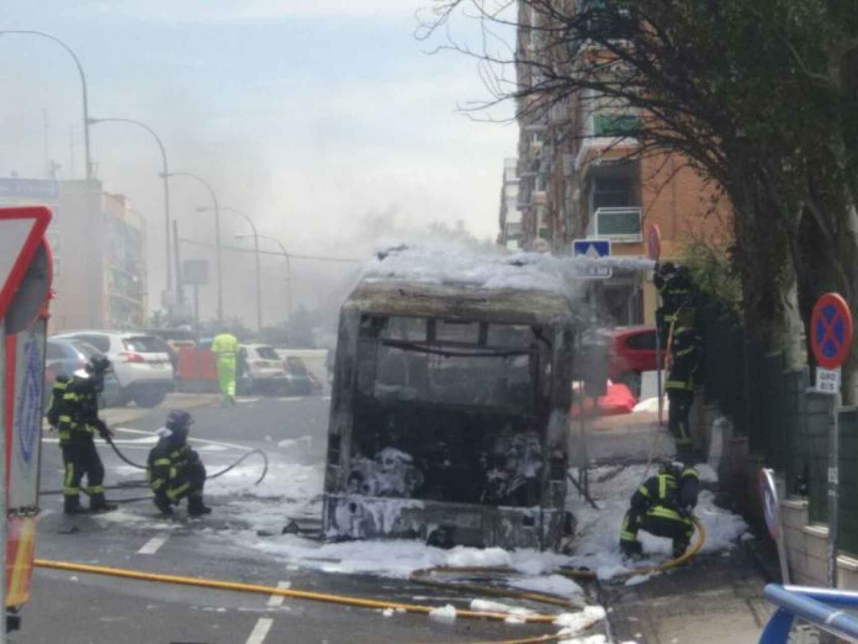 Los bomberos en las labores de extinción del incendio del autobús calcinado el 17 de  julio.