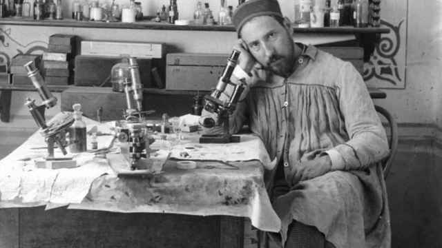 Ramón y Cajal junto a un microoscopio en su despacho.