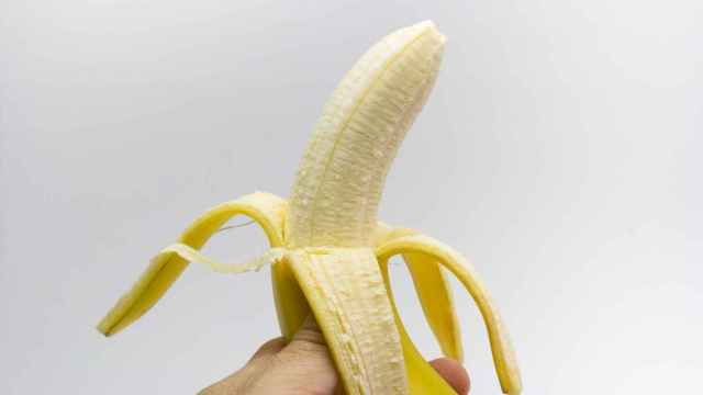 Una banana recién pelada justo hasta la mitad.