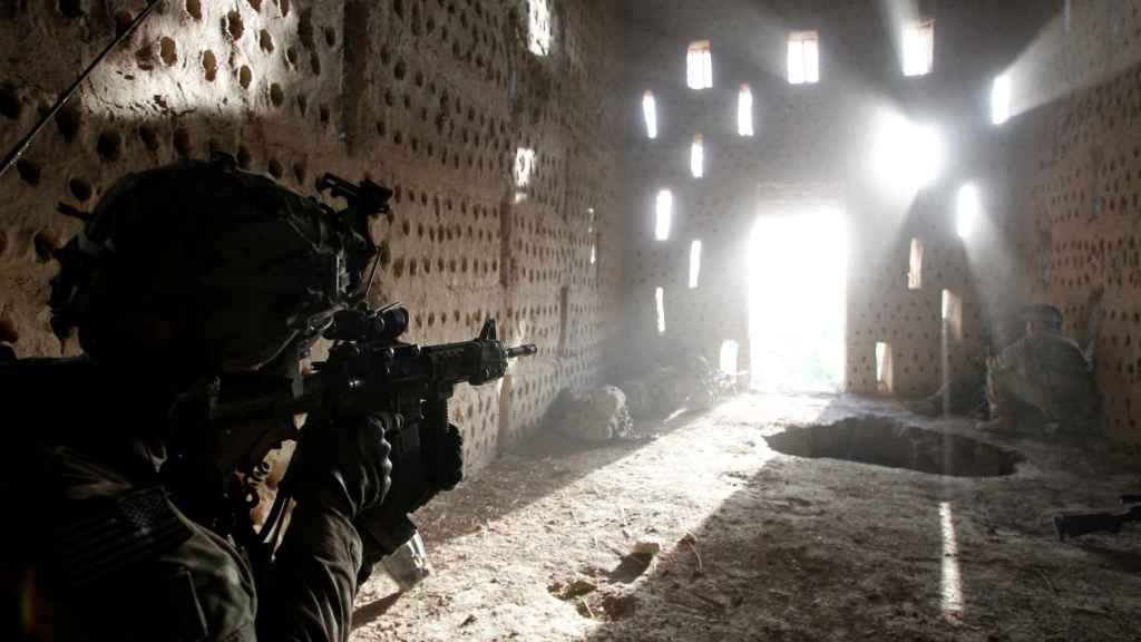 Un soldado estadounidense apunta su rifle a una entrada después de ser atacado por los talibanes en Afganistán.