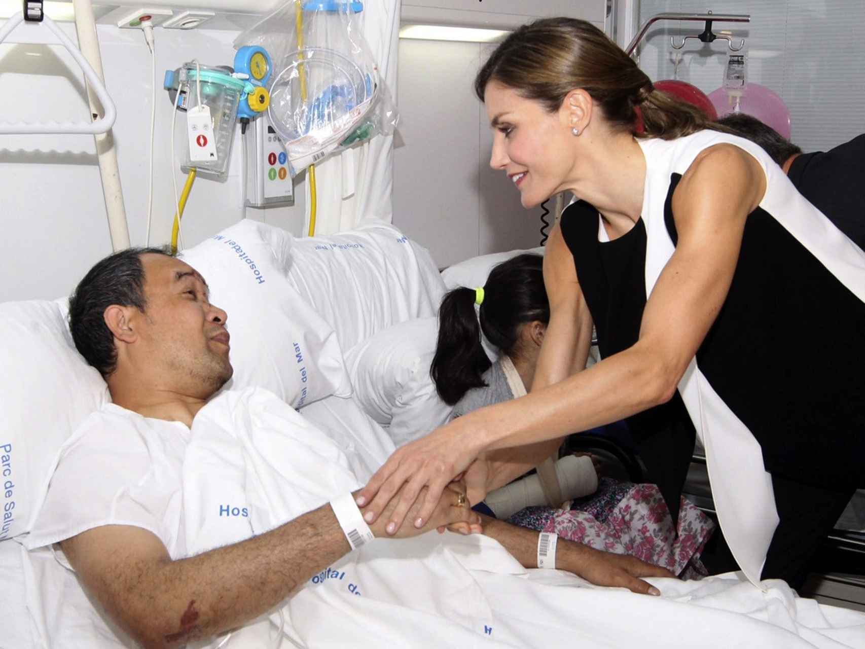 La Reina Letizia saluda a un herido en su visita al Hospital del Mar