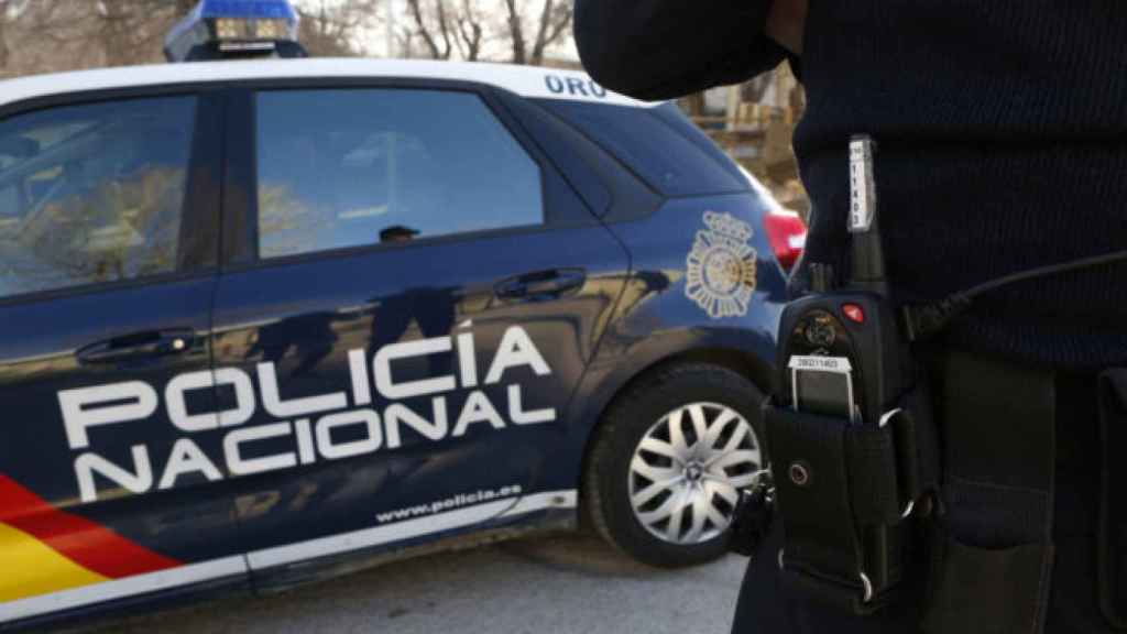 Imagen de archivo de un agente y un coche de la Policía Nacional.
