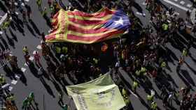 Manifestantes en la Diada despliegan una bandera catalana independentista.