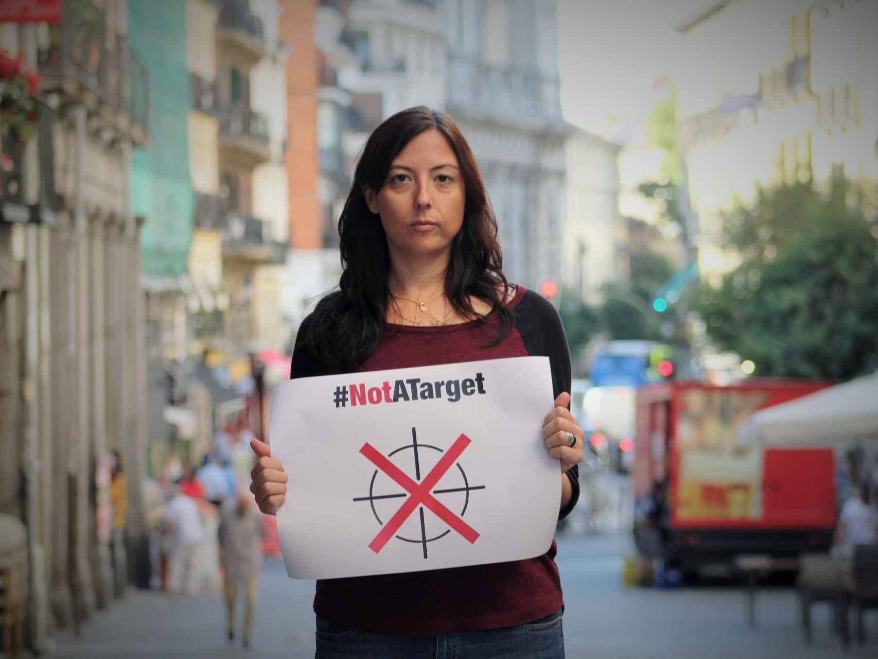 Paula Minguell, en Madrid, con un cartel que reza: No somos un objetivo.