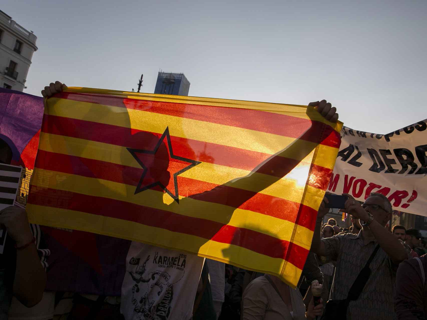 Manifestantes con una estelada en la Puerta del Sol en Madrid.