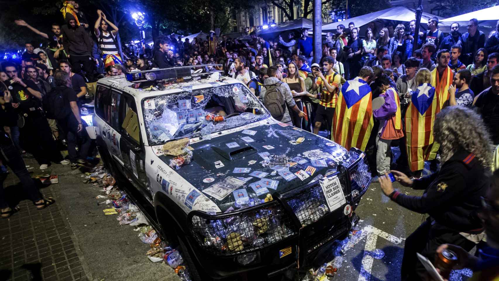 Un coche de la Guardia Civil destrozado en una protesta en Barcelona en 2017.