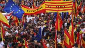 People wave Spanish, Catalan (known as Senyera) and European Union flags during a demonstration in favour of a unified Spain a day before the banned October 1 independence referendum, in Barcelona