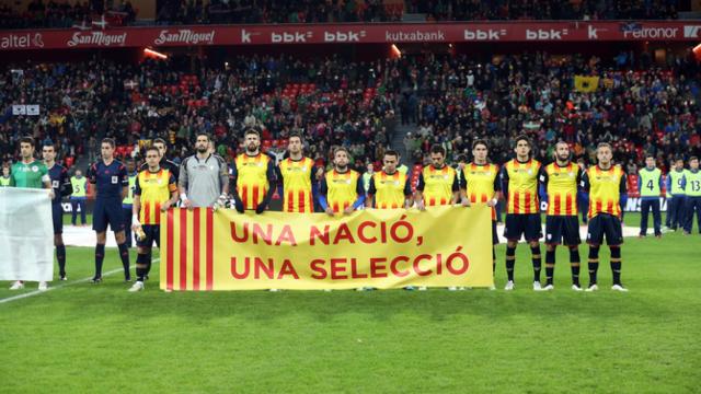 Piqué, junto a otros jugadores catalanes, porta la pancarta 'Una nació, una selecció'.