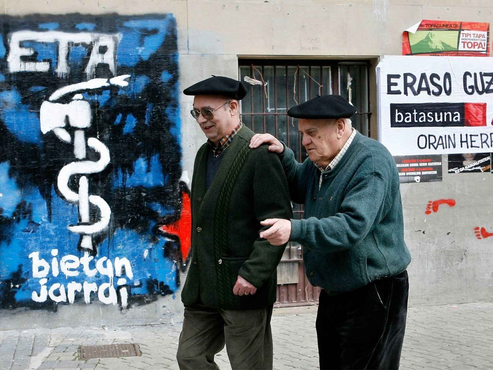 Dos ancianos en Alsasua (Navarra), con fondo de pintadas de ETA.