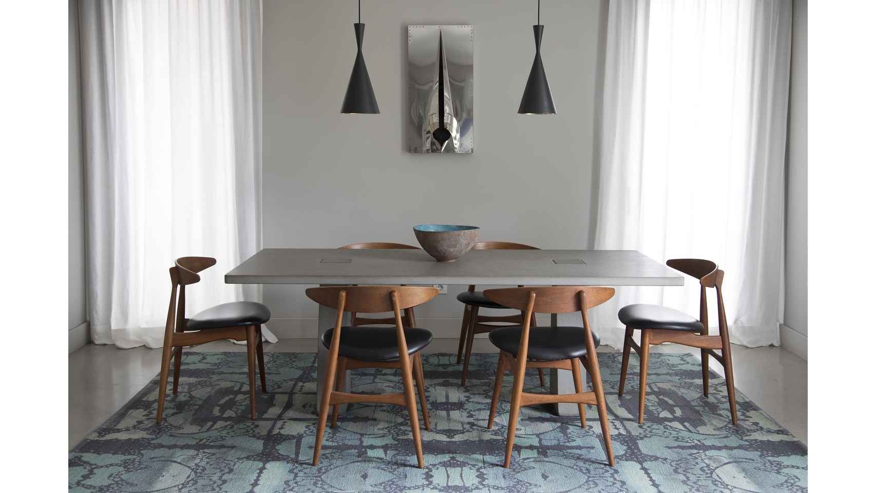 En el comedor, mesa del arquitecto Angelo Mangiarotti, sillas de Hans Wegner, alfombra de Kasthall, lámparas de Tom Dixon y cerámica de Silvia Valentín.