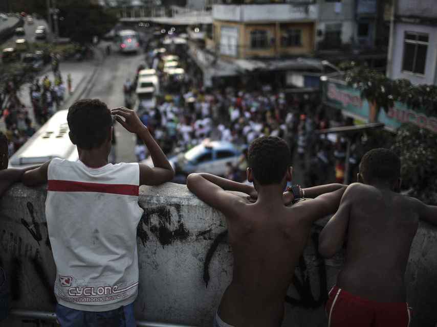 Varios niños de la Rocinha observan el ajetreo en las calles.