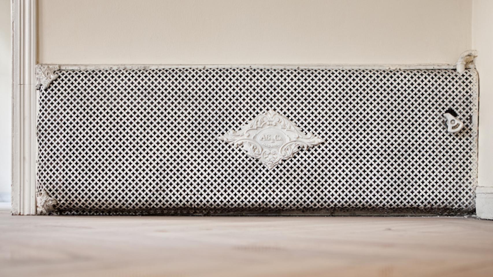 Radiadores empotrados en la pared y ocultos tras una rejilla, toda una innovación para la época.