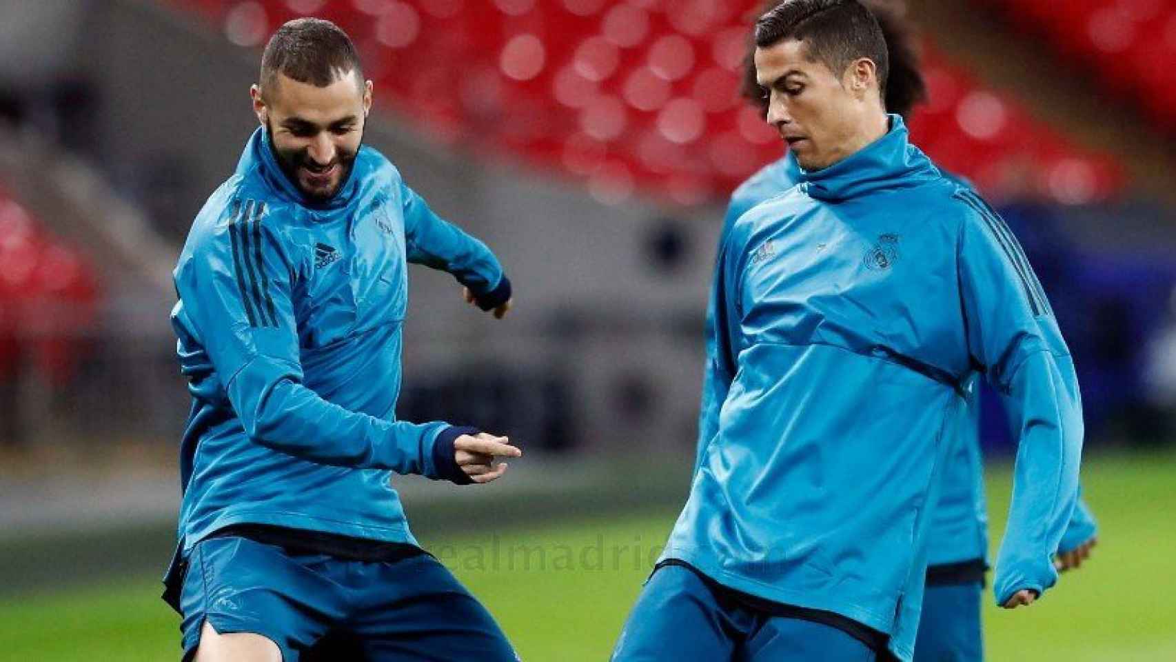 Benzema y Cristiano luchan por un balón.