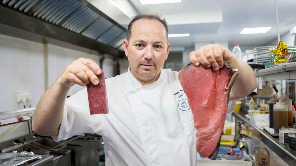 El chef Damián Ríos, del restaurante DeAtún de Madrid, sujeta un filete de atún tintado en su mano izquierda y un trozo de atún rojo de almadraba, la especialidad de su local, en la mano derecha.