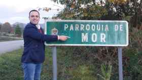 Xabier Pardiñas, teniente de alcalde de Alfoz y responsable del área de turismo, junto al cartel de la parroquia de Mor.