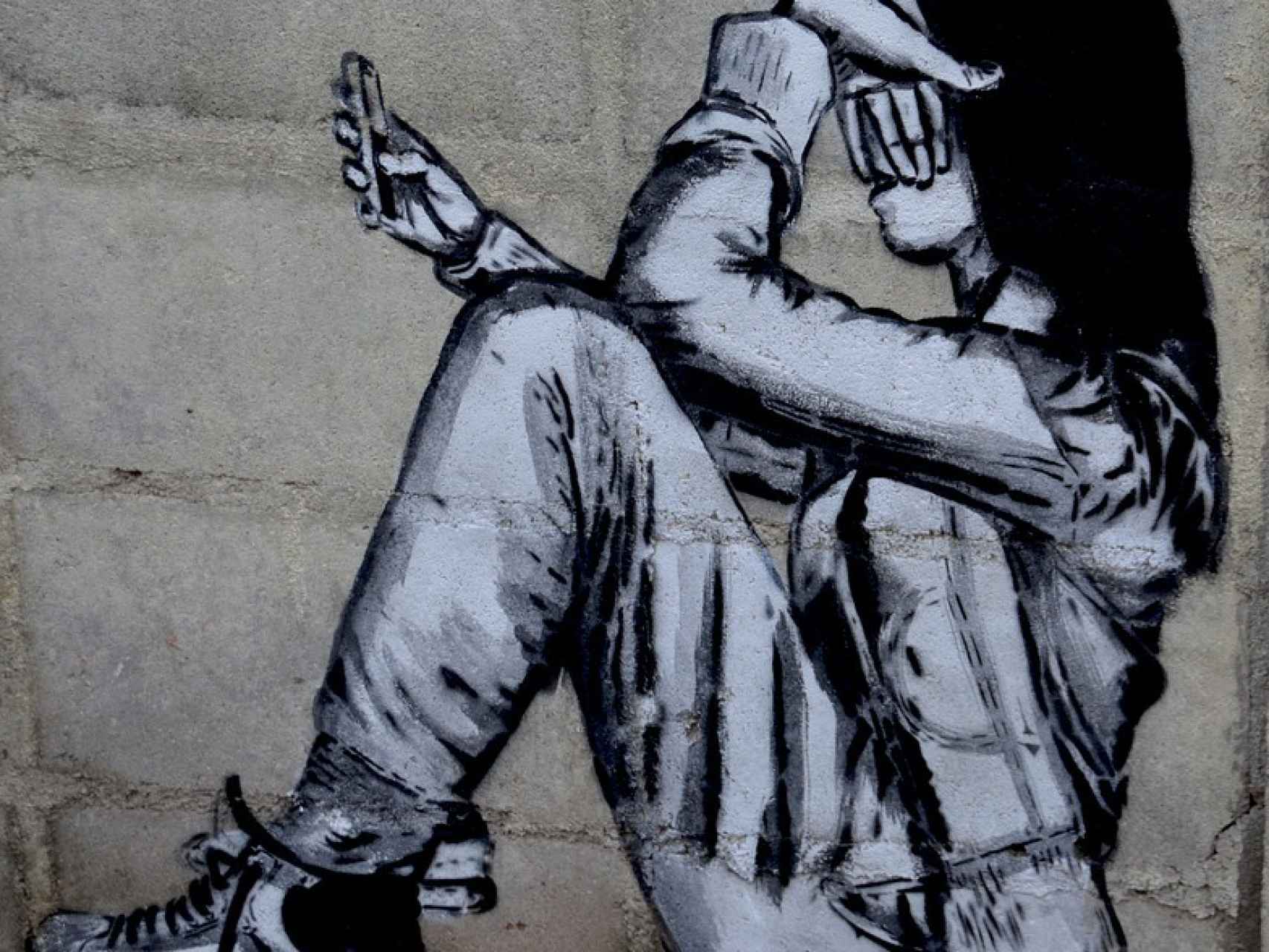 Grafiti de una mujer sufriendo acoso a través del móvil.