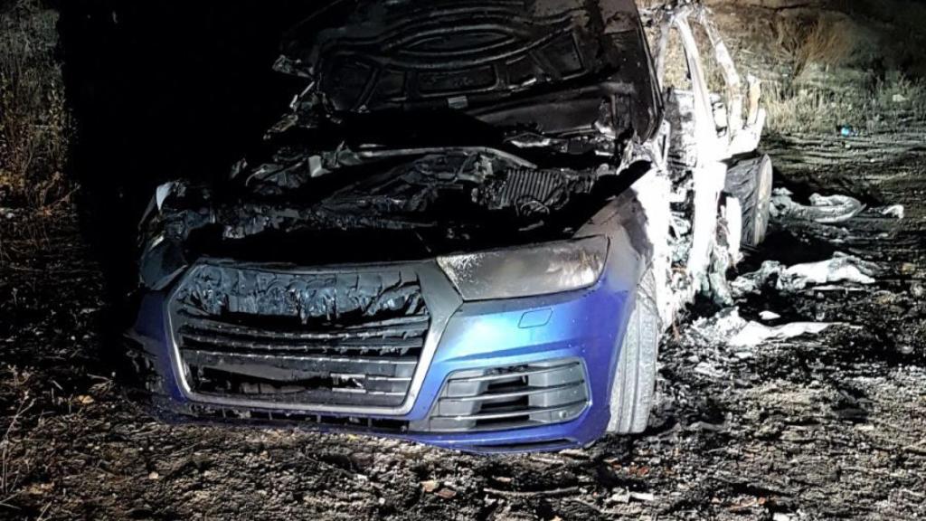 El Audi Q-7, ya calcinado, en el que viajaban los agresores.