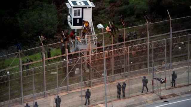 Inmigrantes intentando saltar la valla de Ceuta.