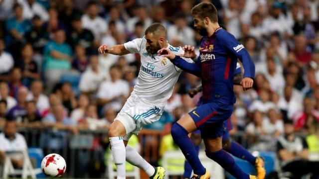 Benzema intenta rematar ante Piqué