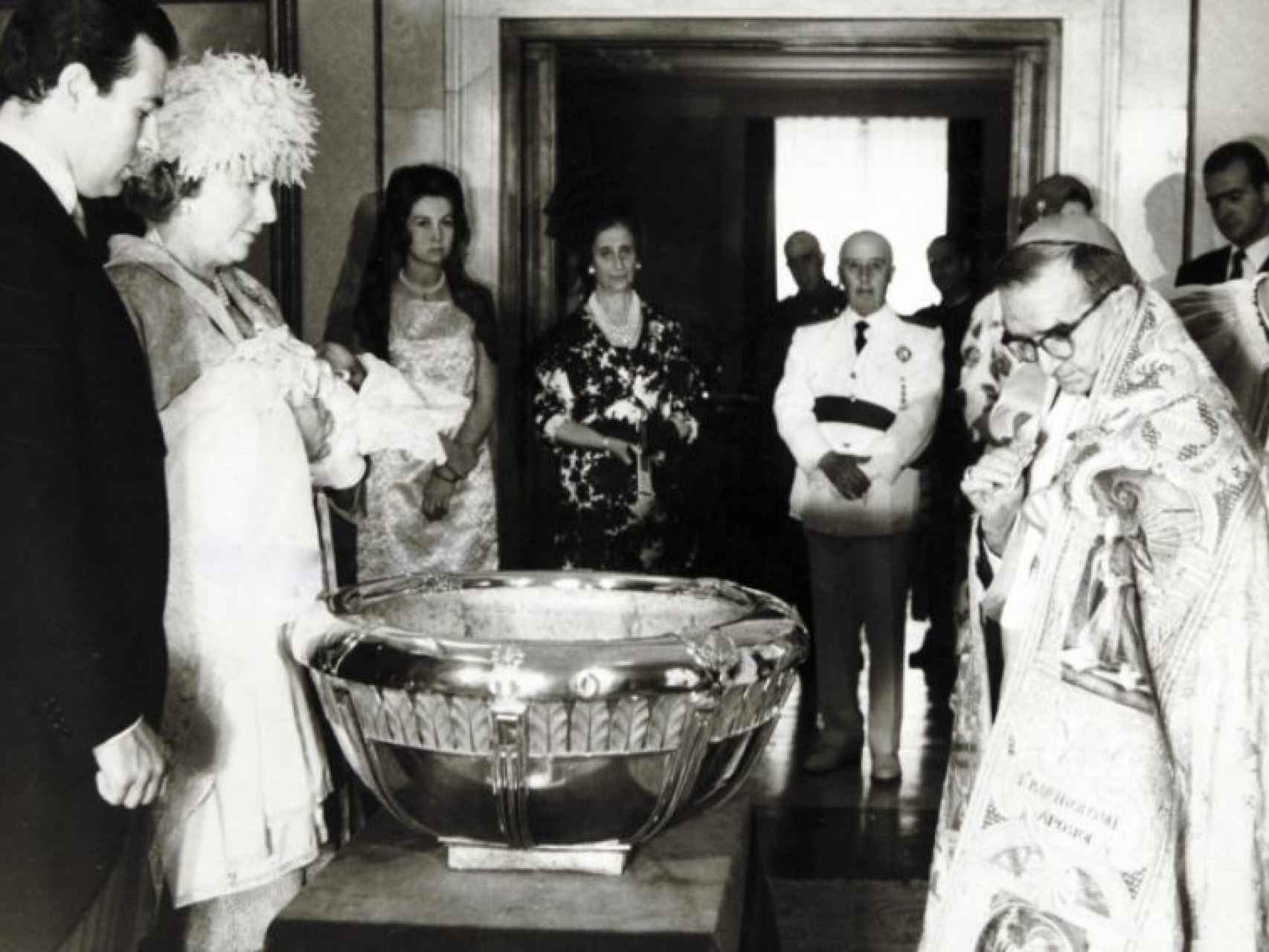 La reina Sofía, Carmen Polo, Franco y el rey Juan Carlos (al fondo a la derecha) en el bautizo de la infanta Elena.