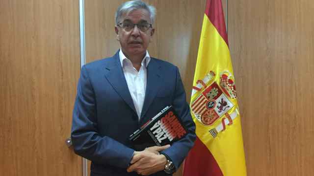 El coronel Sánchez Corbí posa con el libro y la bandera de su despacho.