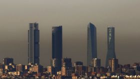 Las cuatro torres de Madrid, tras una nube de contaminación.