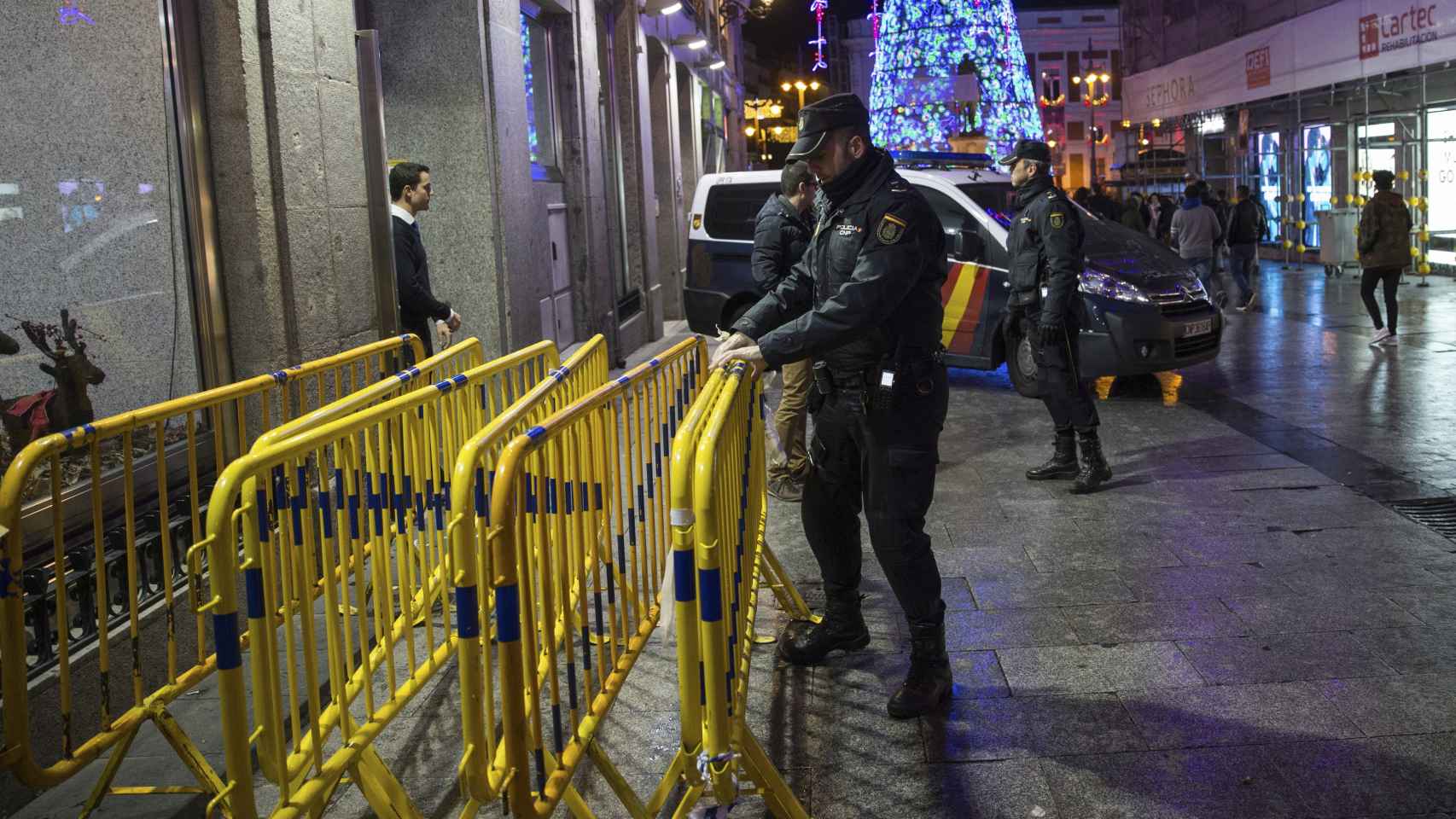 La policía procediendo a instalar vallas en una calle de Madrid.