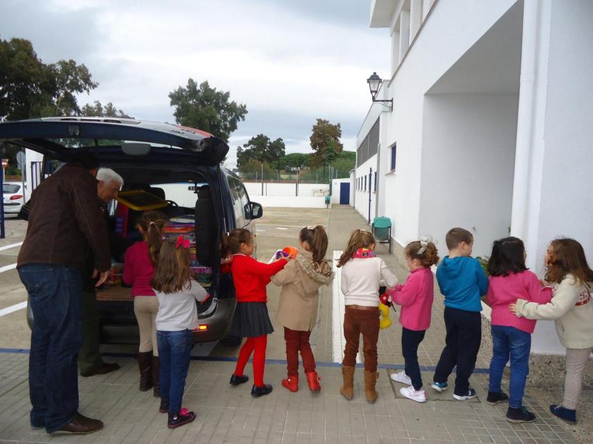 Paco reparte regalos a varios niños.
