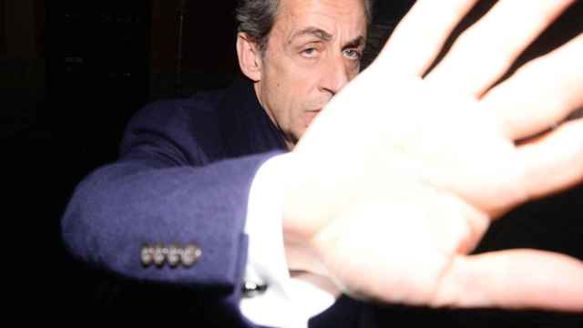 Nicolás Sarkozy tapa una de las cámaras antes de entrar al concierto de su mujer.