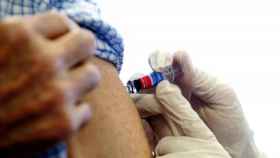 Un médico aplica la vacuna de la gripe.
