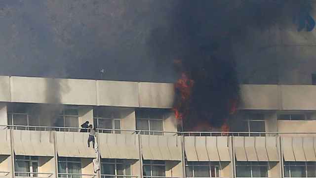 Un hombre trata de escapar por el balcón durante el ataque al hotel Intercontinental de Kabul.