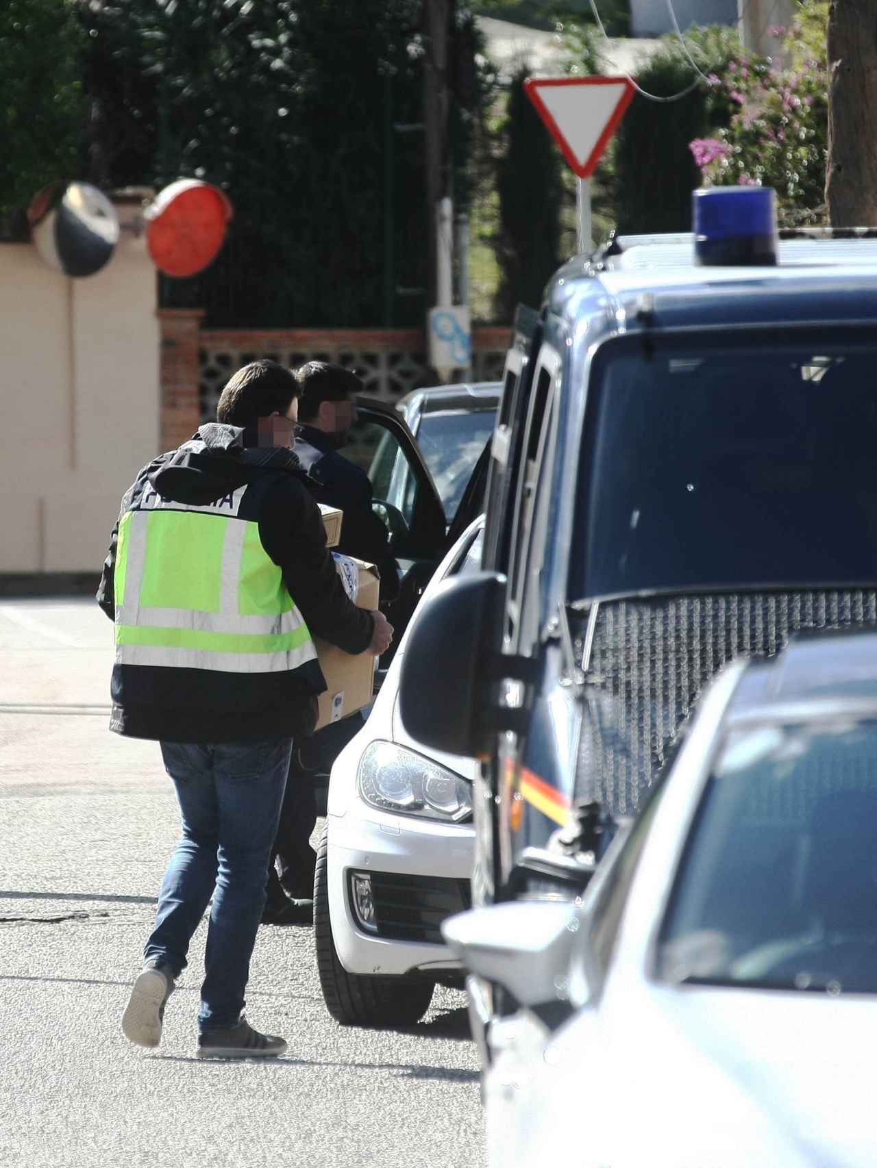 Agentes sacan cajas de la vivienda registrada en la urbanización Colonia San Miguel de la localidad gaditana de Algeciras.