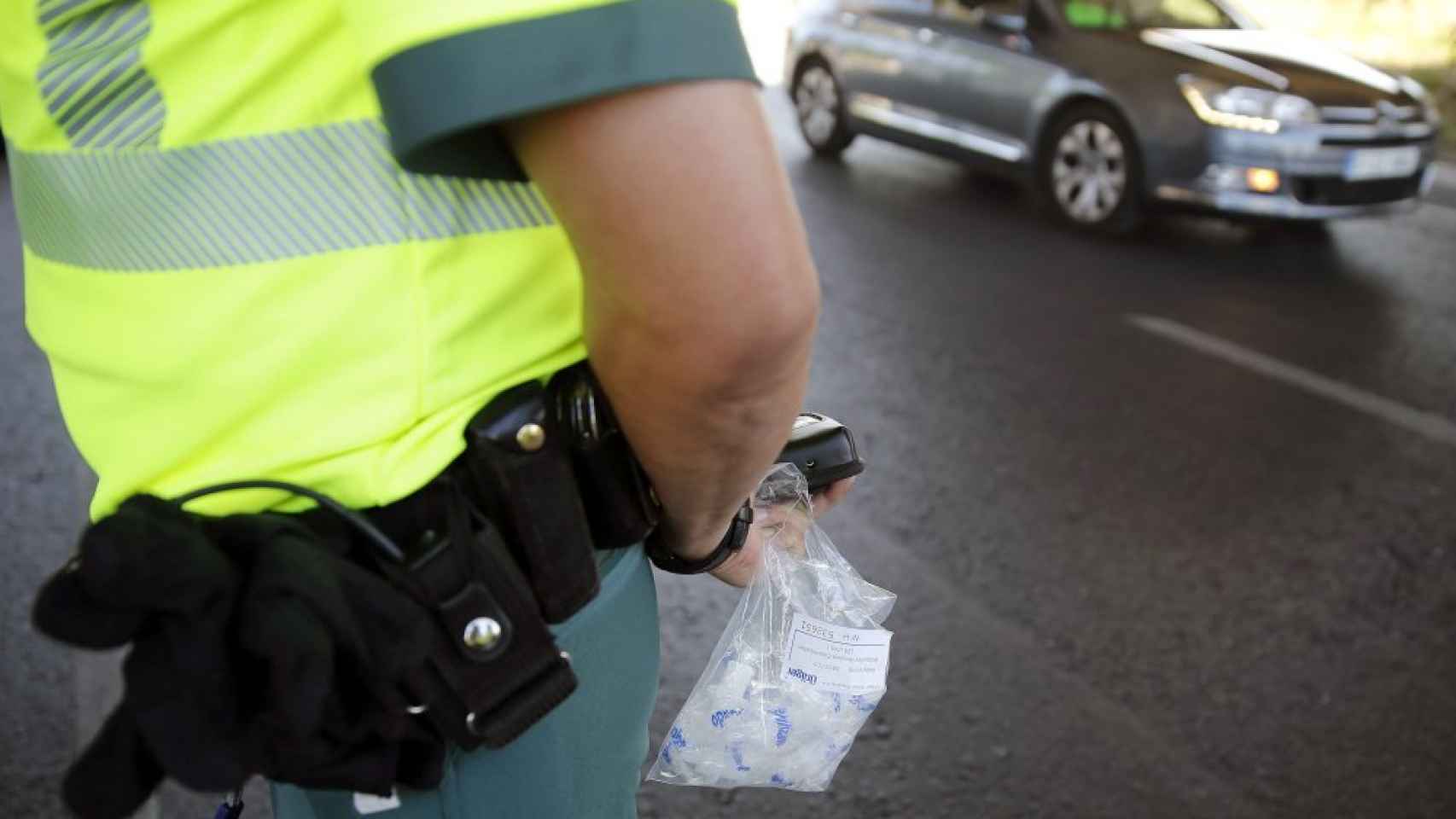 Un agente de la Guardia Civil sostiene una bolsa con boquillas para el control de alcoholemia y drogas.