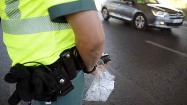 Un agente de la Guardia Civil sostiene una bolsa con boquillas para el control de alcolhemia y drogas.